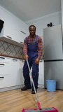 Funny cheerful professional cleaner dances with a mop while washing the floor. Vertical video
