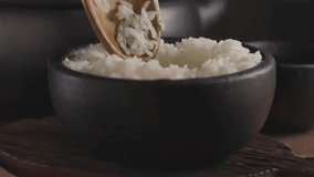Hot cooked white rice in bowl. Video in slow motion.