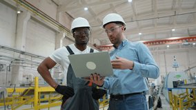 Two diverse factory workers supervisor and subordinate working and discussing manufacturing plan in the factory. Industry and engineering concept - Powered by Shutterstock - Get 15% off with code: PIKWIZARD15