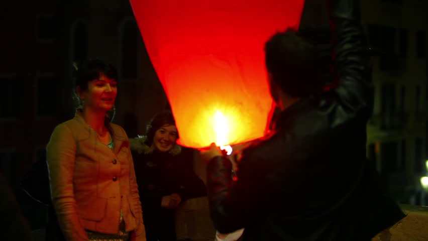 VENICE - CIRCA MAY 2012: Letting a heart shaped paper lantern go in the street