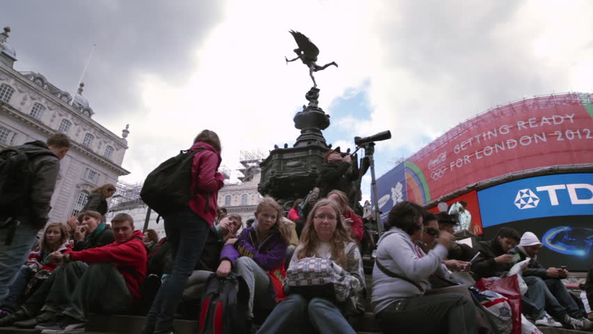 LONDON - OCTOBER 7, 2011:  Crowd sits on the steps of the Eros statue 
