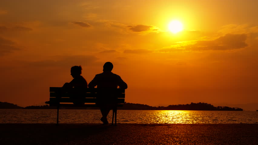 Couple ignoring each other by sea. A wife and man silhouette do not speak on the bench on bay during sunset. Royalty-Free Stock Footage #3468571571