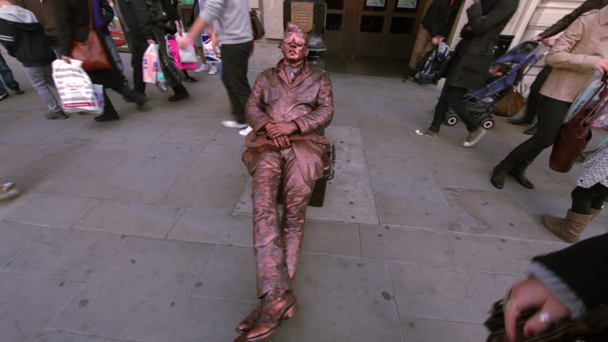 LONDON - OCTOBER 7, 2011: Statue mime and people walking by