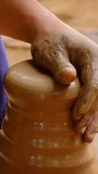 Skilled wet hands of potter shaping the clay on potter wheel and sculpting vase. Manufacturing traditional handmade Indian bowl, jar, pot, jug. Udaipur, Rajasthan, India