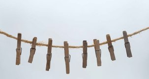 Old wooden clothespins, laundry hooks, on hemp rope, white background