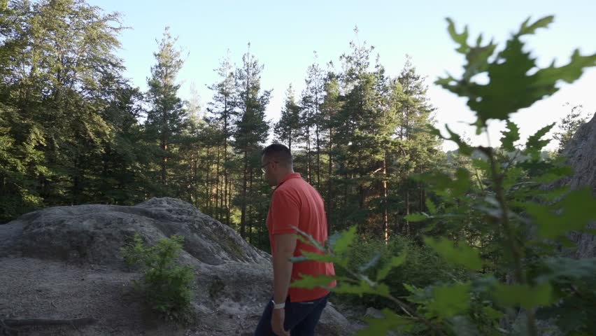 Man wearing a red shirt is walking up the boulders of Eagle