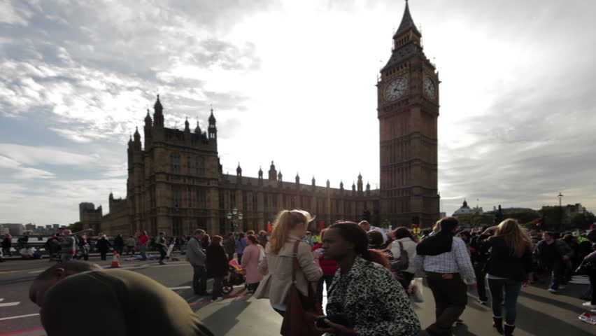 LONDON - OCTOBER 9, 2011:  People walk under Big Ben on a cloudy day