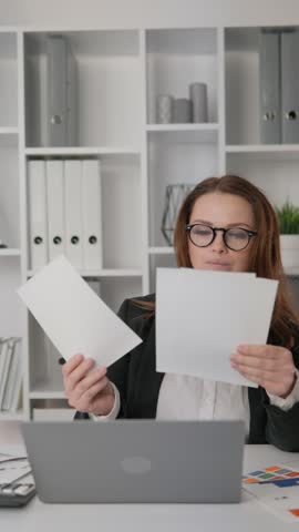 Businesswoman in office carefully analyzing financial reports and revenue growth strategies. Her focus and ability to work with data make her effective in the field of management Royalty-Free Stock Footage #3468933577