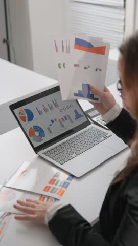Businesswoman in office studying information data on her laptop. She is a master at managing documents and shows unflappable expertise in financial analytics Royalty-Free Stock Footage #3468946299