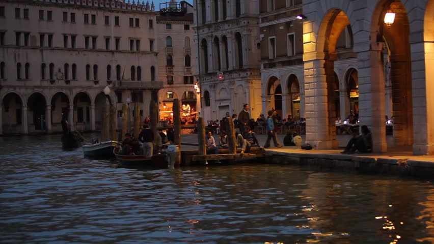 VENICE - CIRCA MAY 2012: Floating at night near docks and a crowd of people 