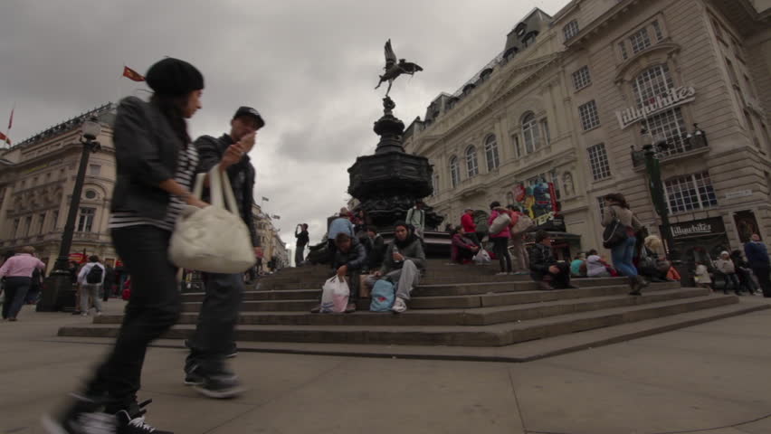 LONDON - OCTOBER 9, 2011: People sit on and walk by the Eros statue