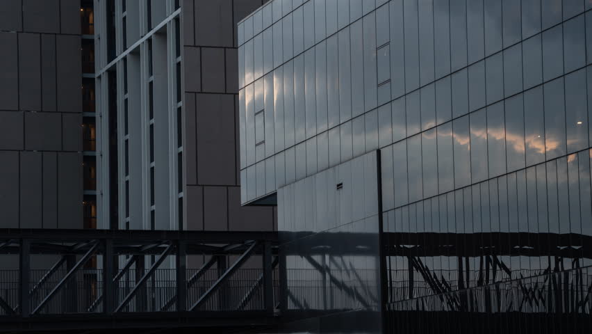 Time lapse Health - a sportive man and woman is jogging at the metal contruction of an iron bridge in the smart green Building. Young woman in the city running on green steel bridge