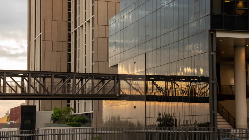 Time lapse Health - a sportive man and woman is jogging at the metal contruction of an iron bridge in the smart green Building. Young woman in the city running on green steel bridge