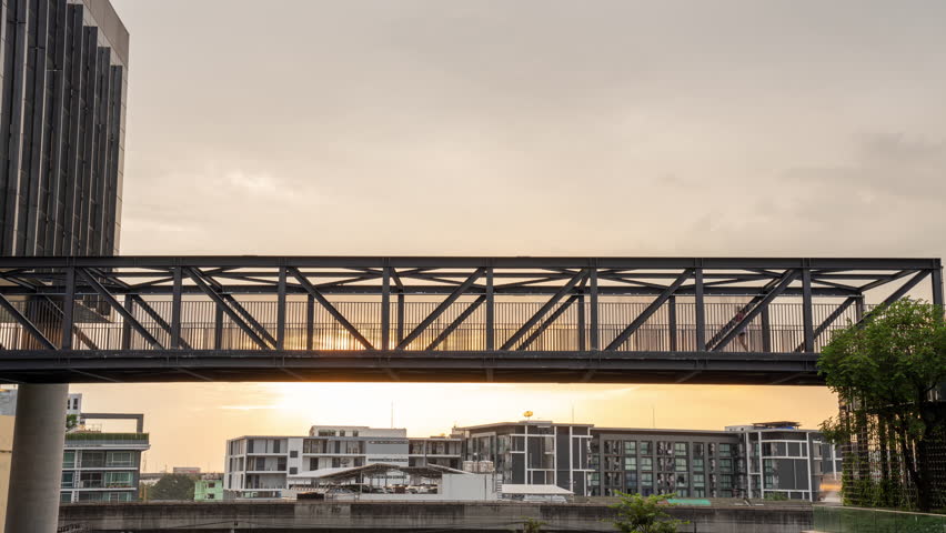 Time lapse Health - a sportive man and woman is jogging at the metal contruction of an iron bridge in the smart green Building. Young woman in the city running on green steel bridge