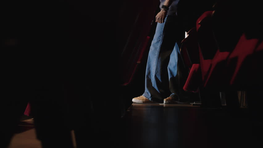 Tracking shot of young Black male standup comedian going down wooden stairs and climbing up on stage to microphone to make performance of his monologue Royalty-Free Stock Footage #3468980093