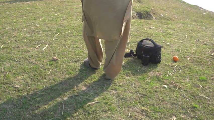 person walking on grass near lake in slow motion