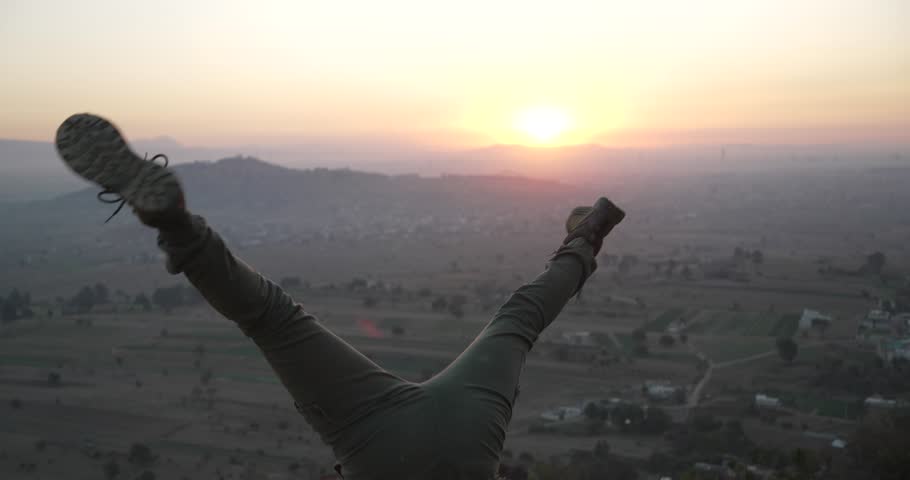 Happy girls stops doing acrobatics in the mountain at sunrise