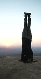 Vertical baklit video of a young mexican girl headstand making movements with her legs