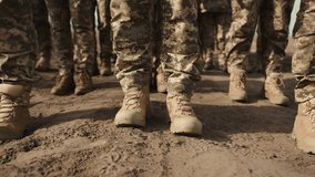 A close-up reveals the dusty boots of soldiers marching in unison through sandy terrain, symbolizing the unity and determination of the military march.  - Powered by Shutterstock - Get 15% off with code: PIKWIZARD15