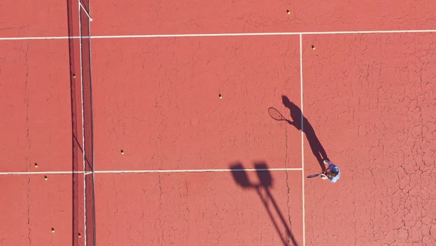 Young woman on a court during tennis training game. Top view