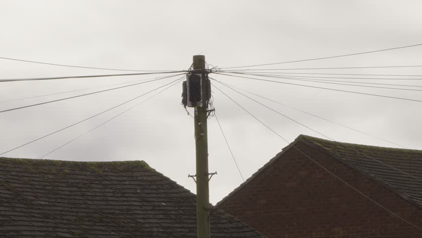 UK telegraph pole with fibre broadband internet installation stock footage