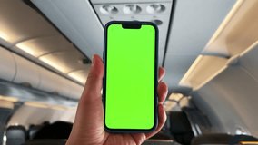 Travel by airplane. Man holding phone with green screen in airplane. Concept of app travel service. Green screen. - Powered by Shutterstock - Get 15% off with code: PIKWIZARD15