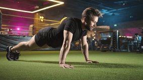 Focused male athlete doing push-ups on artificial grass inside a contemporary gym surrounded by neon lights. Wearing black athletic attire, showcasing strength and endurance. Camera 8K RAW.  - Powered by Shutterstock - Get 15% off with code: PIKWIZARD15