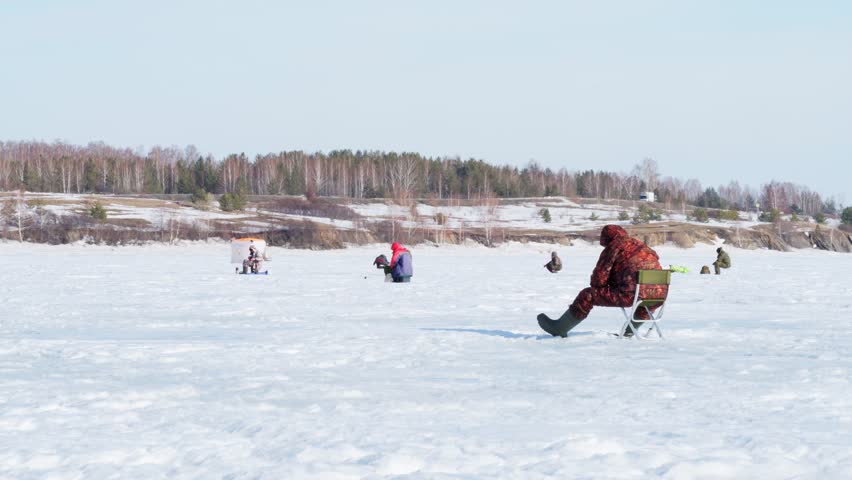 Fishermen on a winter fishing trip catch fish. Winter ice fishing. Man and nature. Royalty-Free Stock Footage #3469359279