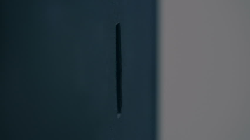 Male fingers inserting a quarter dollar coin into a coin receiver, the light is brightly reflected from the surface of the coin. Closeup. Macro. Slow mo, slo mo, slow motion, high speed camera, 250fps