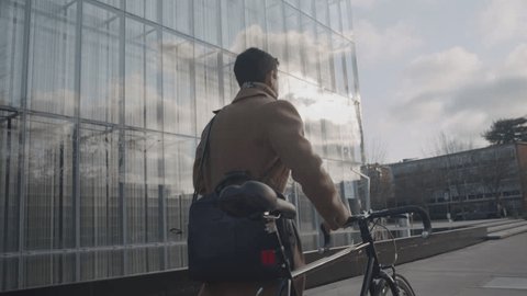 Guy walking bike to corporate job: stockvideo
