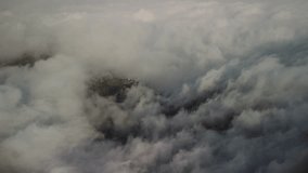 Drone shot over a village on the cliff of the mountain surrounded by clouds