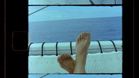 Vintage film clip of feet with the view of the ocean from a boat