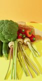Vertical video of fresh vegetables with broccoli and peppers on yellow background. fresh and organic vegetable produce.