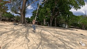 Wide view of happy bikini woman play rope swing under Australian pine on the beach in Koh Kradan island by the Andaman sea ocean on summer holiday. - Powered by Shutterstock - Get 15% off with code: PIKWIZARD15
