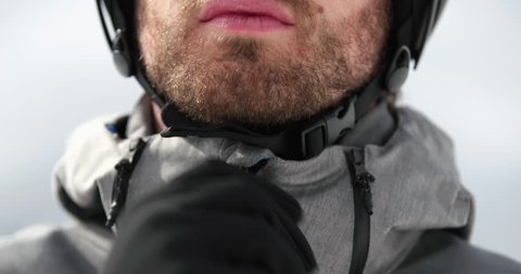 Man face detail closing jacket zip preparing for skiing.Mountaineering ski activity. Skier people winter sport in alpine mountain outdoor.Front view.Slow motion 60p 4k video
