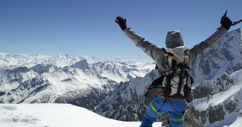 Climber mountaineer man reaching snowy mount top success in sunny day.Mountaineering ski activity. Skier people winter snow sport in alpine mountain outdoor.Back view.Slow motion 60p 4k video