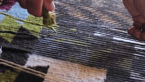 Vertical video footage of the process of traditional, hand made carpet. Ancient carpet weaving technique in Uzbekistan