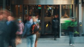 Time-lapse busy shopping mall entrance unrecognizable people crowd enter and exit store through revolving door. Rush hour crowded shopping center, glass door rotating fast motion, blurred faces - Powered by Shutterstock - Get 15% off with code: PIKWIZARD15