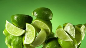 Super Slow Motion of Flying Limes Isolated on Green Background. Filmed on High Speed Cinema Camera, 1000 fps. Speed Ramp Effect. - Powered by Shutterstock - Get 15% off with code: PIKWIZARD15