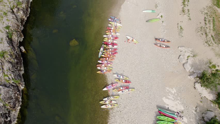 Above View Of Colorful Canoe Boats On The Lakeshore. Aerial Descending Shot