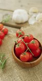Vertical video of fresh ripe red cherry tomatoes and garlic on rustic cloth background. fresh and organic vegetable produce.