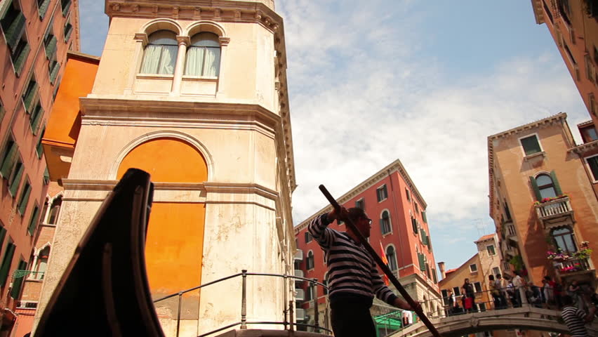 VENICE - MAY 2, 2012: Gondola slows, preparing to cross underneath bridge