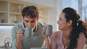 Married couple drinking coffee laughing talking together at home kitchen interior close up. Happy two people in love enjoy morning beverage looking tablet screen. Cheerful spouses having breakfast. - Powered by Shutterstock - Get 15% off with code: PIKWIZARD15