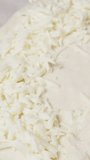 Vertical video. Grated cheese is placed on the dough to be wrapped into a boat shape for Ajarian Khachapuri.