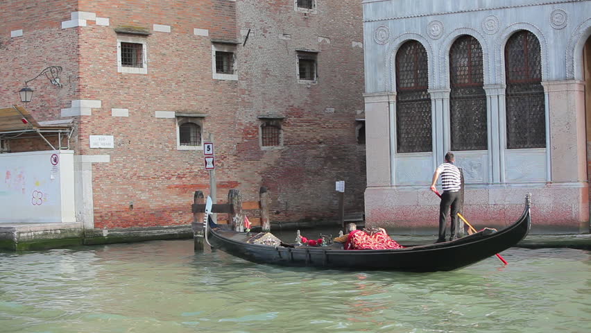VENICE - MAY 2012: Gondolier steering through canal in Venice.
