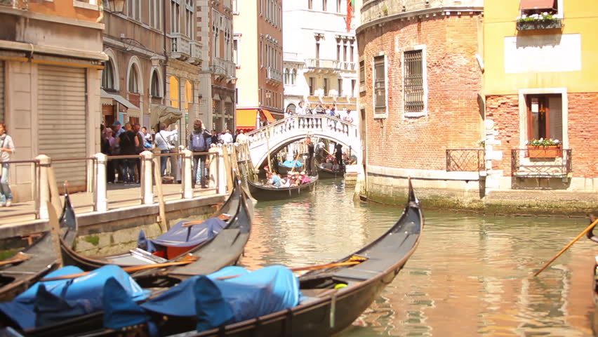 VENICE - MAY 2, 2012: A gondola pulls into a docking area as others travel down