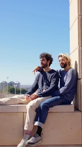 Homosexual young couple talking together. Two men relaxing and enjoying outdoors.
