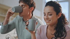 Smiling spouses drinking coffee looking digital tablet in kitchen close up. Joyful couple watching social media surfing internet on computer at home. Happy family shopping online at morning breakfast. - Powered by Shutterstock - Get 15% off with code: PIKWIZARD15