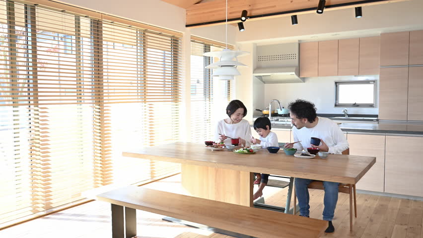 parents and children smiling as they dine in the bright dining room.