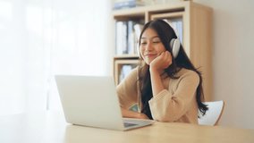Young asian woman wearing headset while working on computer laptop at house. Work at home, Video conference, Video call, Student learning online class - Powered by Shutterstock - Get 15% off with code: PIKWIZARD15